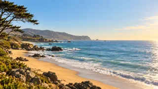 Verano · Costa: Costa rocosa, arena y mar azul al sol.